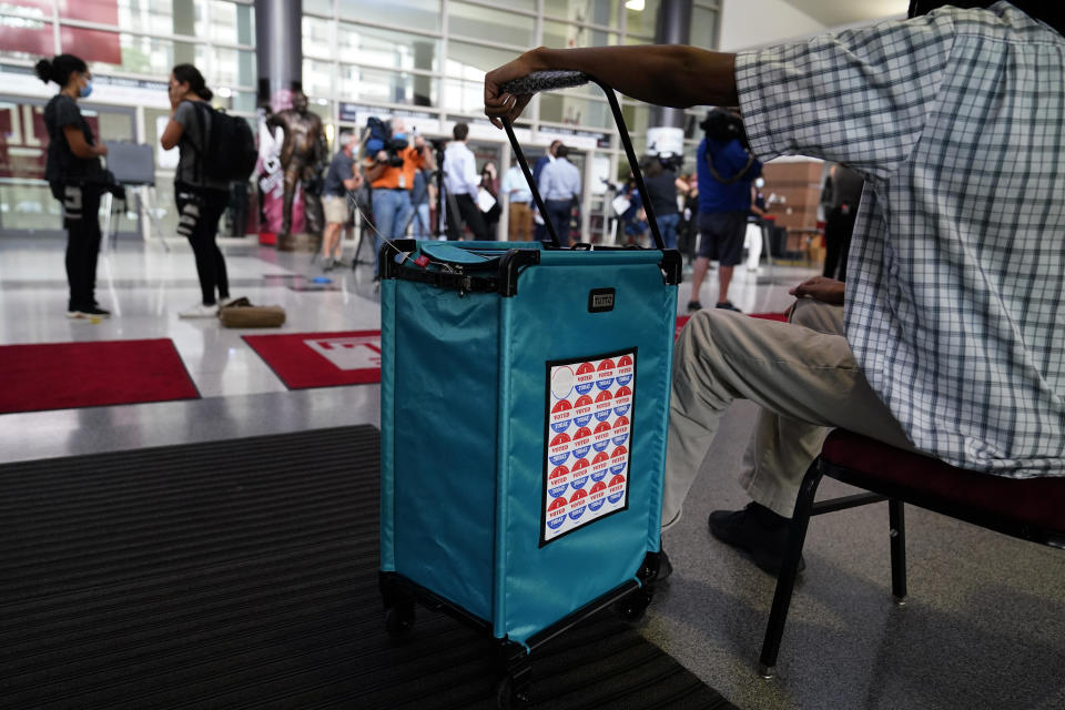 A poll worker hangs on the ballot box at a satellite election office at Temple University's Liacouras Center, September 29, 2020, in Philadelphia. / Credit: Matt Slocum/AP
