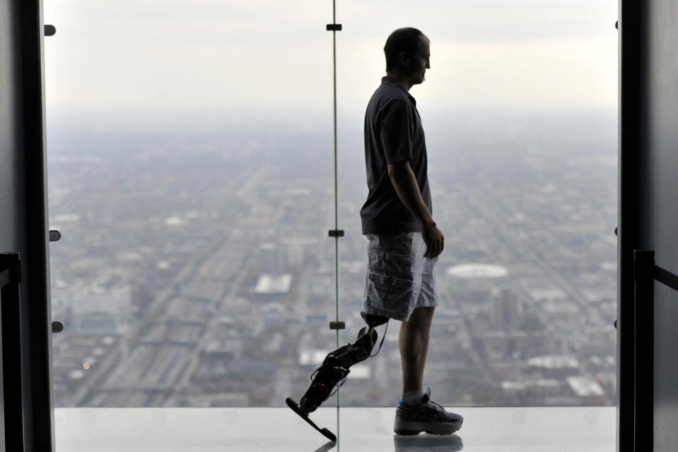 In this Oct. 25, 2012 photo, Zac Vawter, fitted with an experimental "bionic" leg, is silhouetted on the Ledge at the Willis Tower in Chicago. Vawter is training for the world's tallest stair-climbing event where he'll attempt to climb 103 flights to the top of theWillis Tower using the new prosthesis. (AP Photo/Brian Kersey)