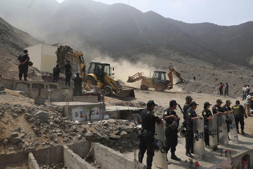 Peruvian authorities demolish a Shining Path mausoleum in a cemetery on the outskirts of Lima, Peru, Saturday, Dec. 29, 2018. Peruvian authorities destroyed the mausoleum on Saturday where eight Shining Path prisoners were killed in a massacre that took place in a prison more than three decades ago. They relocated the remains to a cemetery in a neighborhood in the northern part of the capital. (AP Photo/Martin Mejia)