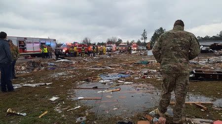 A U.S. Air Force airman surveys debris covering an area of the Sunshine Acres neighborhood after a tornado struck Adel, Georgia. Courtesy of Nathaniel Sixberry/Handout via Reuters