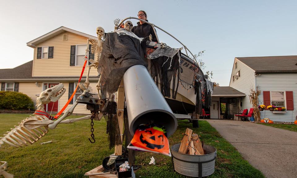 Heather Schrey, of Levittown, Penn.,  gets ready for Halloween during the COVID-19 pandemic, by testing the chute that candy, and ghost pops will slide through for the trick or treaters on Thursday, Oct. 22, 2020.