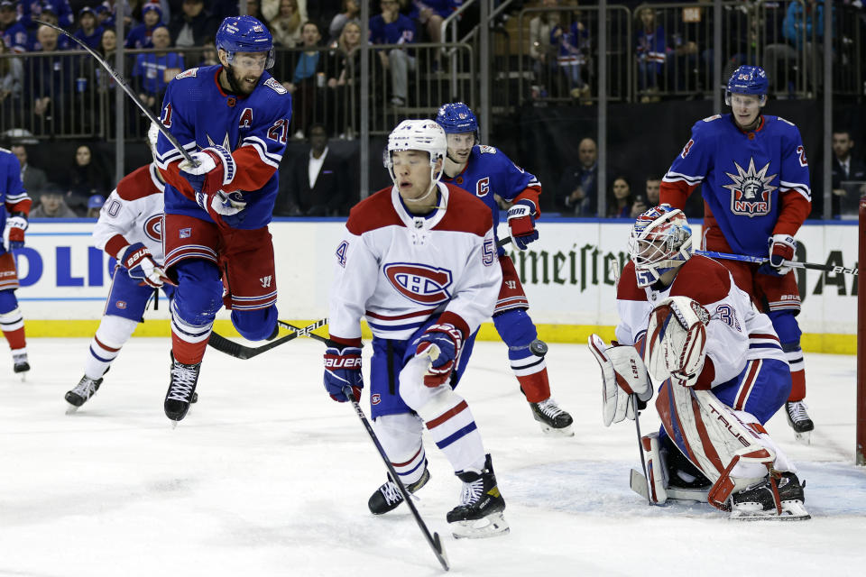 Montreal Canadiens goaltender Sam Montembeault, front right, defends against a shot as New York Rangers center Barclay Goodrow (21) jumps in the second period of an NHL hockey game Sunday, Jan. 15, 2023, in New York. (AP Photo/Adam Hunger)