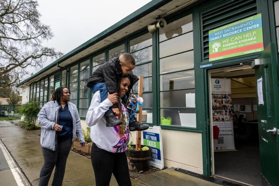 Marquisha Brown, left, carries son Elijah Washington, 6, outside the Yolo County Children’s Alliance in West Sacramento after visiting with her Yolo Basic Income program caseworker Monique Johnson, left, on March 28, 2023. She said the YOBI program allowed her to have time with her son to help with his trauma.