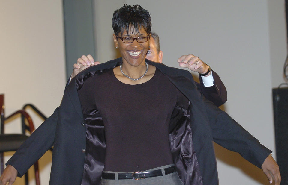 FILE - Lynette Woodard smiles as John L. Doleve, president and CEO of the Basketball Hall of Fame helps her put on her Hall of Fame jacket at a news conferernce at the Hall of Fame in Springfield, Mass., Friday, Sept. 10, 2004. Woodard averaged 26.3 points per game during her four-year career with the Kansas Lady Jayhawks between 1977 and 1981. Iowa's Caitlin Clark will soon be the NCAA's scoring leader. That's fact and, in many minds, enough to put the 22-year-old star high up among the greats of college basketball. (AP Photo/Bob Child, File)