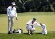 U.S. golfer Bubba Watson (L) and his wife Angie (C) watch their son Caleb putt on the ninth green during the Par 3 Contest ahead of the 2014 Masters golf tournament at the Augusta National Golf Club in Augusta, Georgia April 9, 2014. REUTERS/Jim Young (UNITED STATES - Tags: SPORT GOLF)