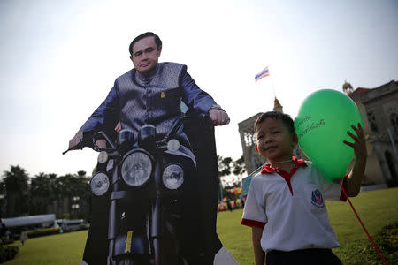 A boy poses next to a cardboard cut-out of Thailand's Prime Minister Prayuth Chan-ocha during preparations for national Children's Day at Government House in Bangkok, Thailand, January 12, 2018. REUTERS/Athit Perawongmetha