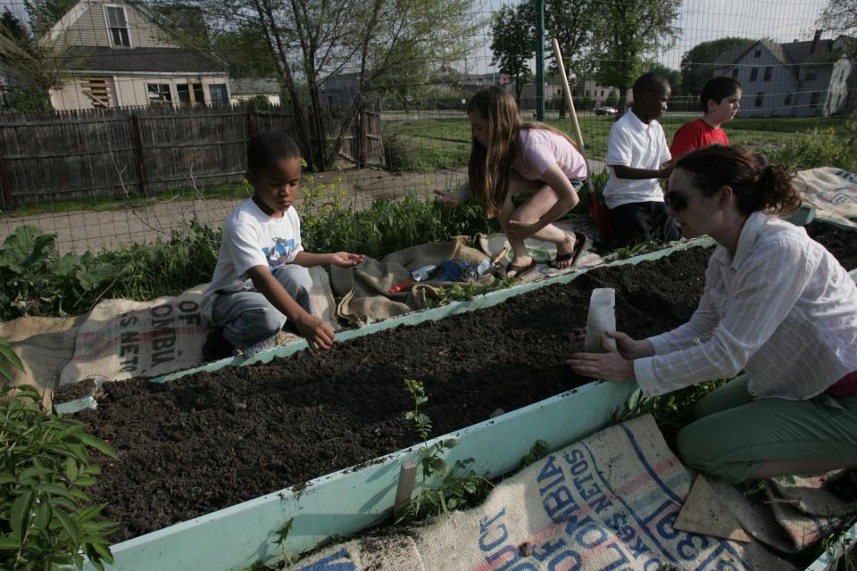 Volunteer, Eve Vandallsen, of Detroit, shows Kobe May, 5, Augusta Spors, 9, Danquan Reddex, 9, and Andrew Boyd, 10, how to plant carrots and golden beets as part of "Growing Healthy Kids" in May of 2007 The program is a partner project of Earthworks Urban Farm of the Capuchin Soup Kitchen's and Iroquois WISE Coalition, of Detroit.