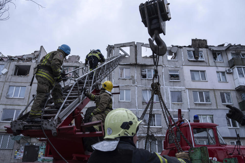 Rescue workers climb by ladder as they clear the rubble of the residential building which was destroyed by a Russian rocket in Pokrovsk, Ukraine, Wednesday, Feb. 15, 2023. According to local authorities 2 people were killed and 12 injured (AP Photo/Evgeniy Maloletka)