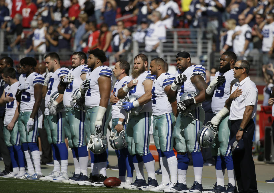 Dallas Cowboys players stand during the performance of the national anthem before a game against the San Francisco 49ers last season. (AP)