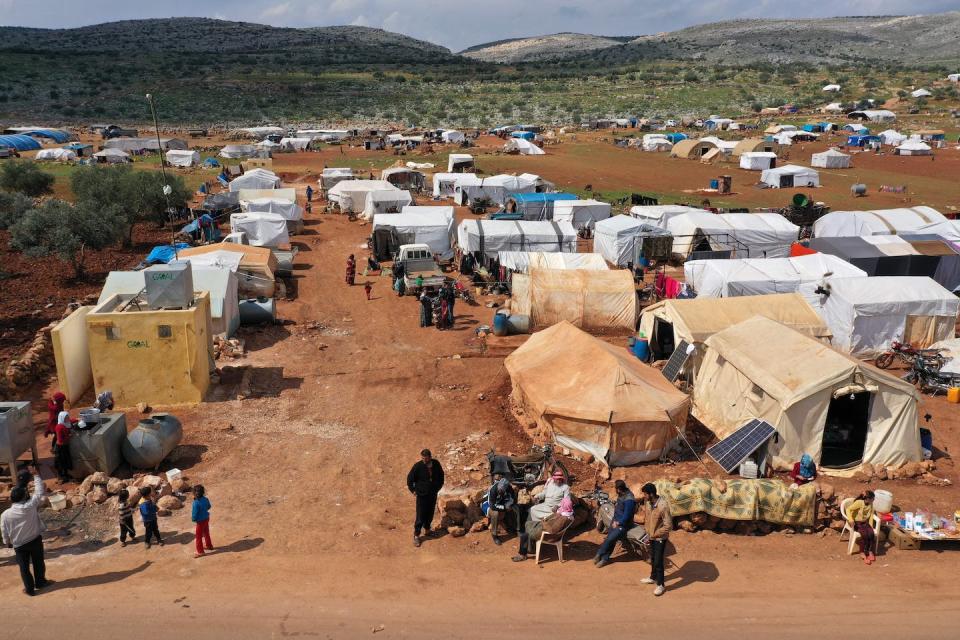 Displacement camps in Syria’s Idlib province pack people closely together, with no running water. <a href="https://www.gettyimages.com/detail/news-photo/drone-image-taken-on-march-17-shows-a-displaced-camp-in-the-news-photo/1207507564" rel="nofollow noopener" target="_blank" data-ylk="slk:Omar Haj Kadour/AFP via Getty Images;elm:context_link;itc:0;sec:content-canvas" class="link ">Omar Haj Kadour/AFP via Getty Images</a>