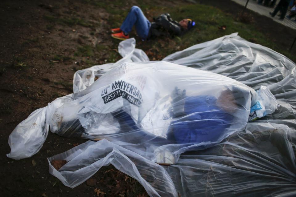 A runner covers himself from the low temperatures and strong wind before the start of the New York City Marathon in New York, November 2, 2014. REUTERS/Eduardo Munoz (UNITED STATES - Tags: SPORT ATHLETICS)