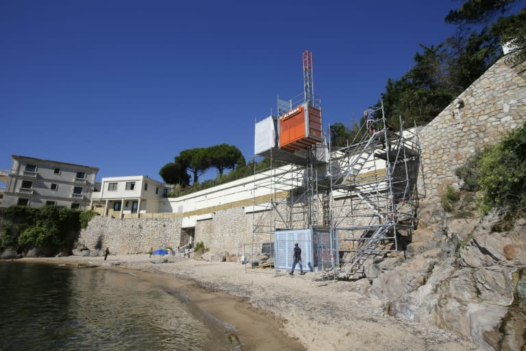 Workers disassemble an elevator on the public beach near the Saudi King's villa in the Golfe-Juan seaside resort in Vallauris, southeastern France, on August 3, 2015
