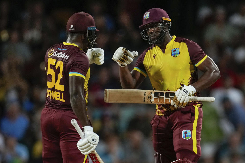West Indies' batsmen Andre Russell and Rovman Powell celebrate runs during their partnership against England in the first T20 cricket match at Kensington Oval in Bridgetown, Barbados, Tuesday, Dec. 12, 2023. (AP Photo/Ricardo Mazalan)
