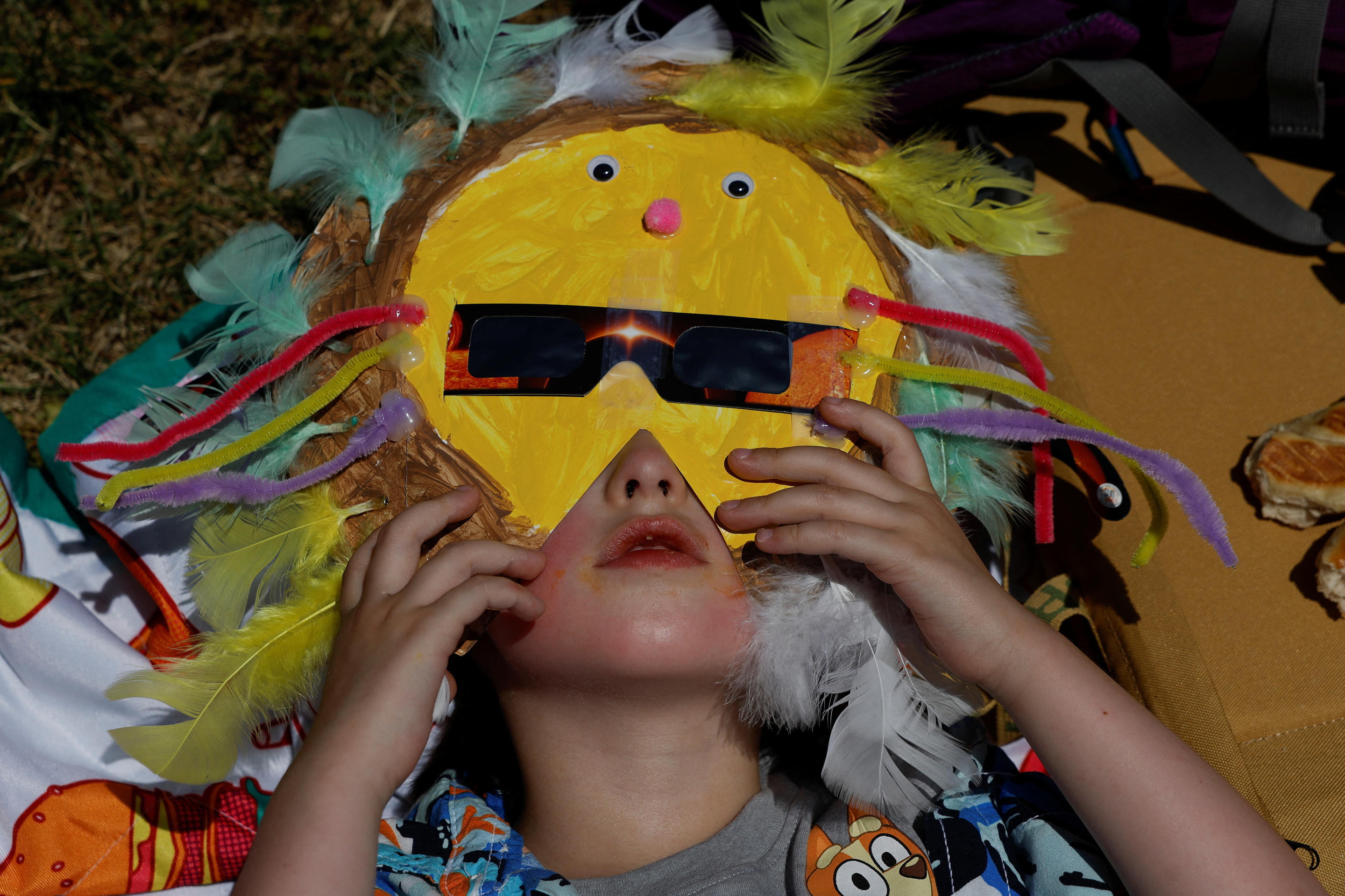 Judah Terlep, 4, wears a mask with solar eclipse glasses, ahead of a total solar eclipse, where the moon will blot out the sun, in Carbondale, Ill. ipse, where the moon will blot out the sun, in Carbondale, Illinois on April 8, 2024. (Evelyn Hockstein/Reuters)