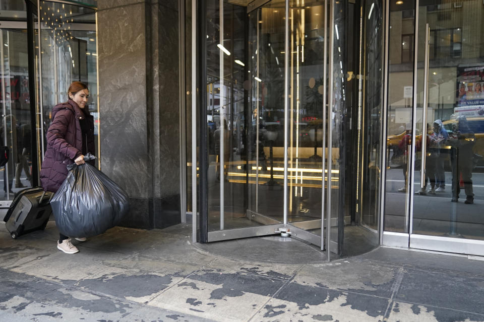 Mayra Martinez, of Colombia, leaves the Row Hotel with her belongings, Tuesday, Jan. 9, 2024, in New York. (AP Photo/Mary Altaffer)