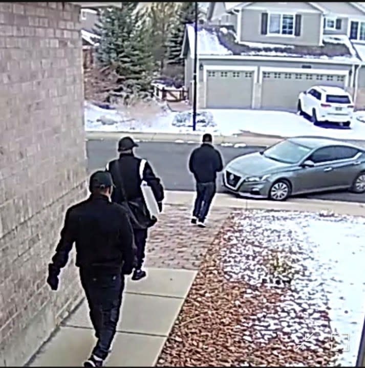 Suspects walking to a Nissan sedan.