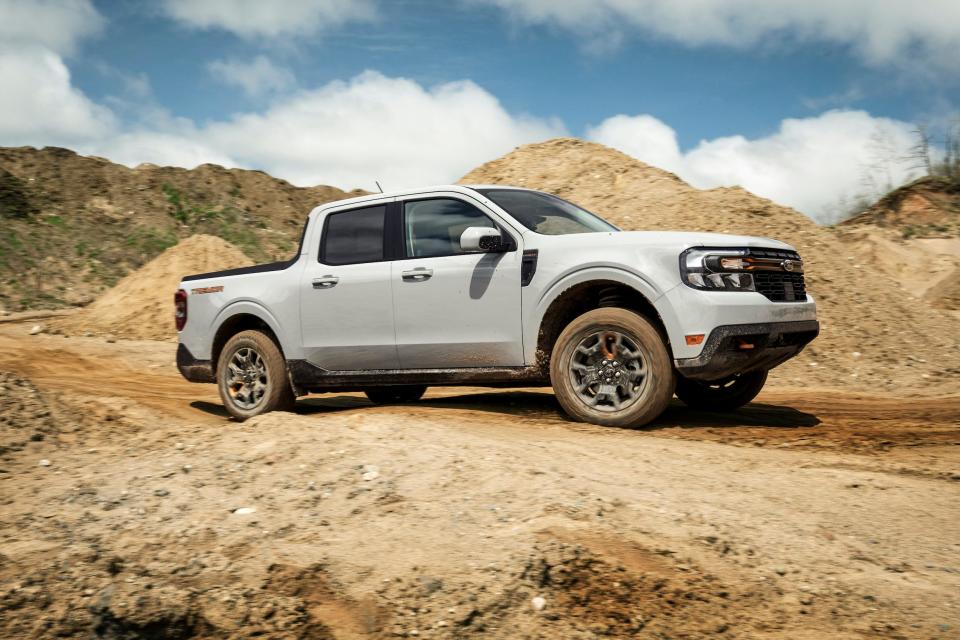 A white 2023 Ford Maverick Tremor pickup truck is parked on mounds of dirt.