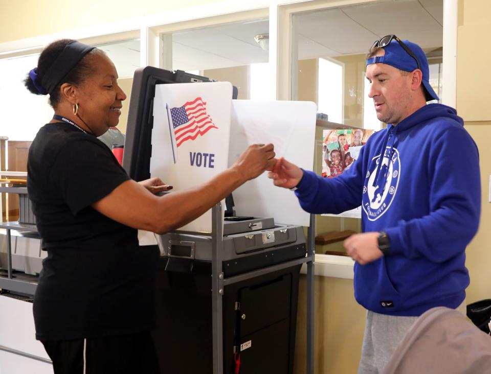 Machine inspector Mary White gives Rob Booth of South Nyack a sticker after he voted with his son at Living Christ Church polling station in South Nyack Nov. 5, 2019. 