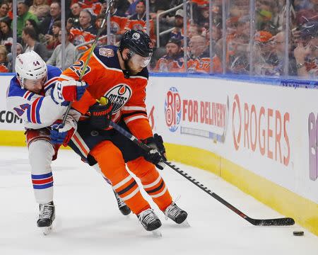 Mar 11, 2019; Edmonton, Alberta, CAN; New York Rangers defensemen Neal Pink (44) and Edmonton Oilers forward Leon Draisaitl (29) battles along the boards for a loose puck during the third period at Rogers Place. Mandatory Credit: Perry Nelson-USA TODAY Sports