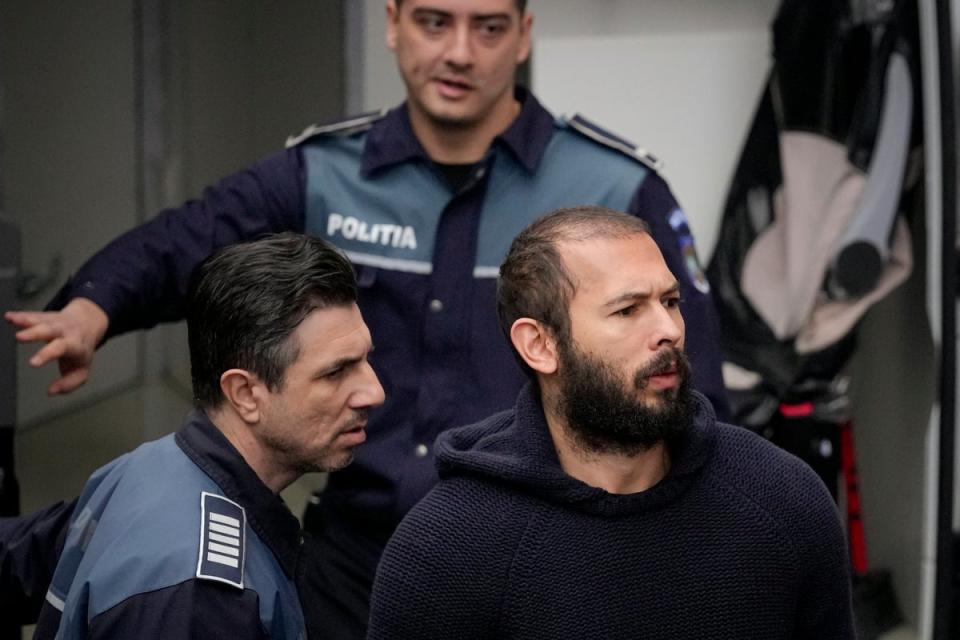 Police officers escort Andrew Tate, center, handcuffed to his brother Tristan Tate, to the Court of Appeal in Bucharest (Copyright 2023 The Associated Press. All rights reserved)