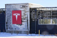 Snow covers the burned remains of a Tesla dealership after wildfires ravaged the area Sunday, Jan.2, 2022, in Superior, Colo. Investigators are still trying to determine what sparked a massive fire in a suburban area near Denver that burned neighborhoods to the ground and destroyed nearly 1,000 homes and other buildings. (AP Photo/Jack Dempsey)