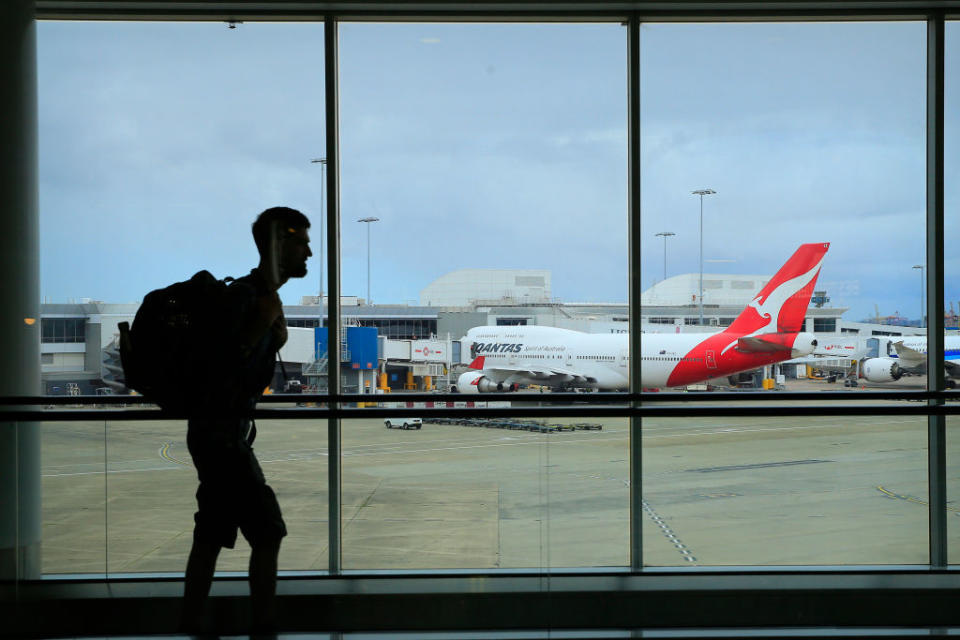 A passenger walks past a Qantas jet at the International terminal at Sydney Airport.