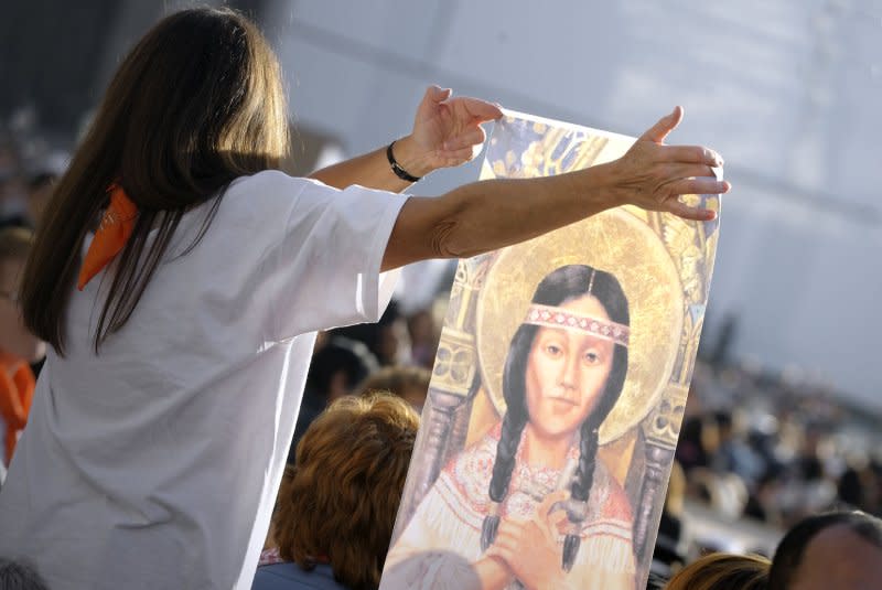 A woman holds a painting representing Kateri Tekakwitha in St. Peter's Square in the Vatican City on October 21, 2012. Pope Benedict XVI canonized Tekakwitha as the first Native American saint. File Photo by Stefano Spaziani/UPI