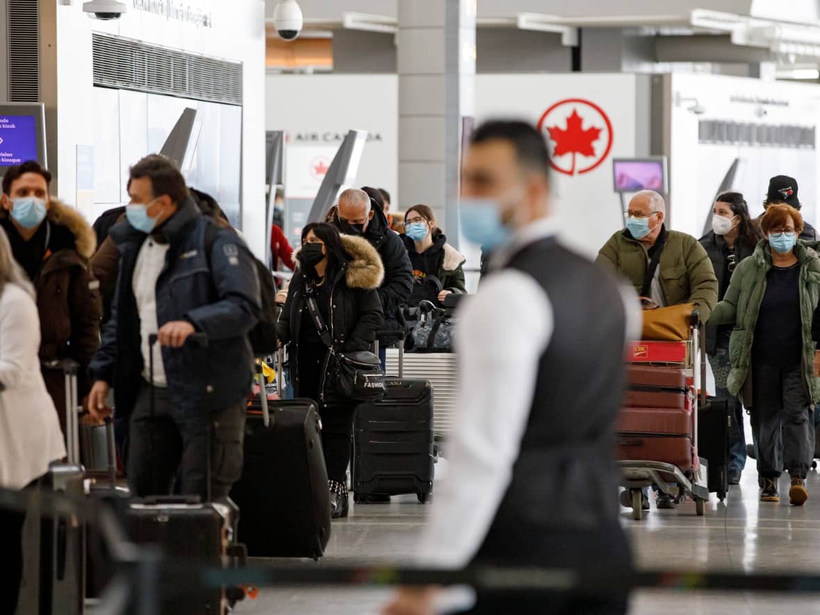 Travellers walk through Pearson airport, in Toronto, on Dec. 16, 2021. (Evan Mitsui/CBC - image credit)