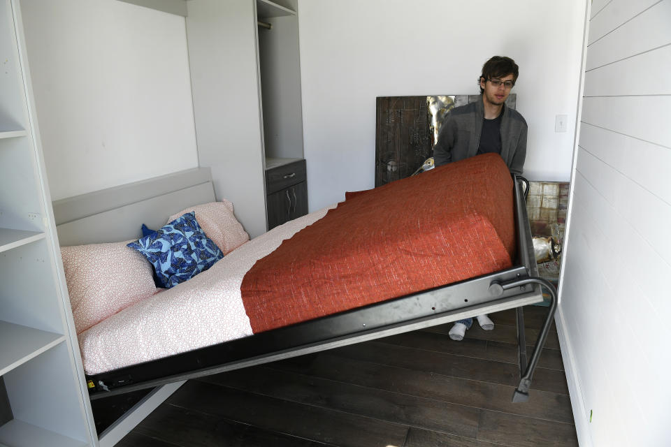 DENVER, CO - OCTOBER 3 - Alex Sundt, of the University of California, Berkeley, puts up a murphy bed so he can move the wall to the right up against it to create more space in the living room of the home that will be competing in the U.S. Department of Energy Solar Decathlon on October 3, 2017 in Denver, Colorado. The moveable wall runs on 5 tracks that allow the home owner to create more space in the living room or more space in the bedroom. All the furniture is against the wall or goes into the wall such as the bed.  The U.S. Department of Energy Solar Decathlon is a collegiate competition made up of 10 contests that challenge student teams to design and build full-size, solar-powered houses. The winner of the competition is the team that best blends design excellence and smart energy production with innovation, market potential, and energy and water efficiency. The Solar Decathlon 2017 is being held adjacent to the 61st & Peña station on the University of Colorado A line commuter train. The exhibition opens to the public on Oct. 5.  (Photo by Helen H. Richardson/The Denver Post via Getty Images)