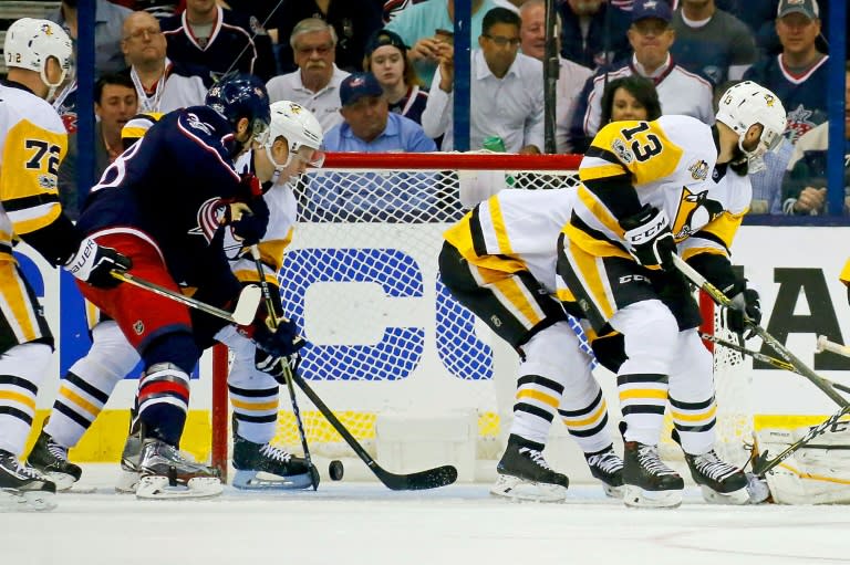 Boone Jenner (2nd L) of the Columbus Blue Jackets flips the puck past Olli Maatta of the Pittsburgh Penguins for a goal in Game Four of the Eastern Conference first round playoffs, at Nationwide Arena in Columbus, Ohio, on April 18, 2017