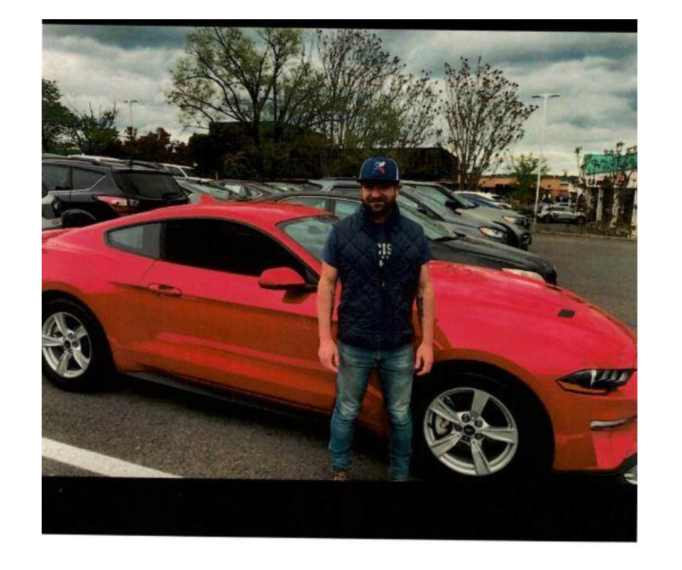 Adam Nettina poses in front of his Ford Mustang in a photo included in an FBI affidavit for his arrest.