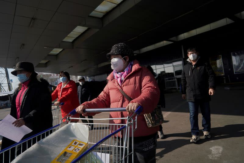 Customers wearing face masks leave a supermarket, as the country is hit by an outbreak of the novel coronavirus, in Beijing
