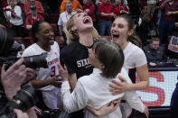 Stanford head coach Tara VanDerveer, bottom, is congratulated by forwards Nunu Agara, top left to right, forward Cameron Brink and guard Hannah Jump after the team's victory over Oregon State in an NCAA college basketball game, Sunday, Jan. 21, 2024, in Stanford, Calif. VanDerveer broke the college basketball record for wins with the victory. (AP Photo/Godofredo A. Vásquez)
