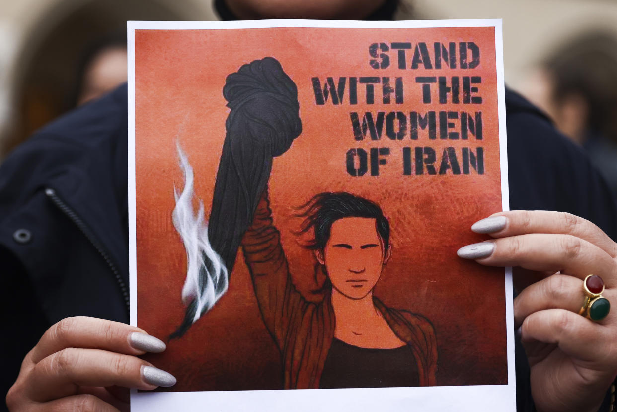 A banner reading Stand With the Women of Iran, held by a protester in Krakow, Poland.