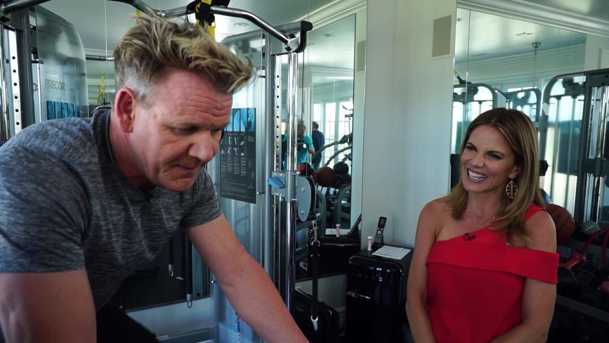 Gordon Ramsey exercises on a bike next to Natalie Morales