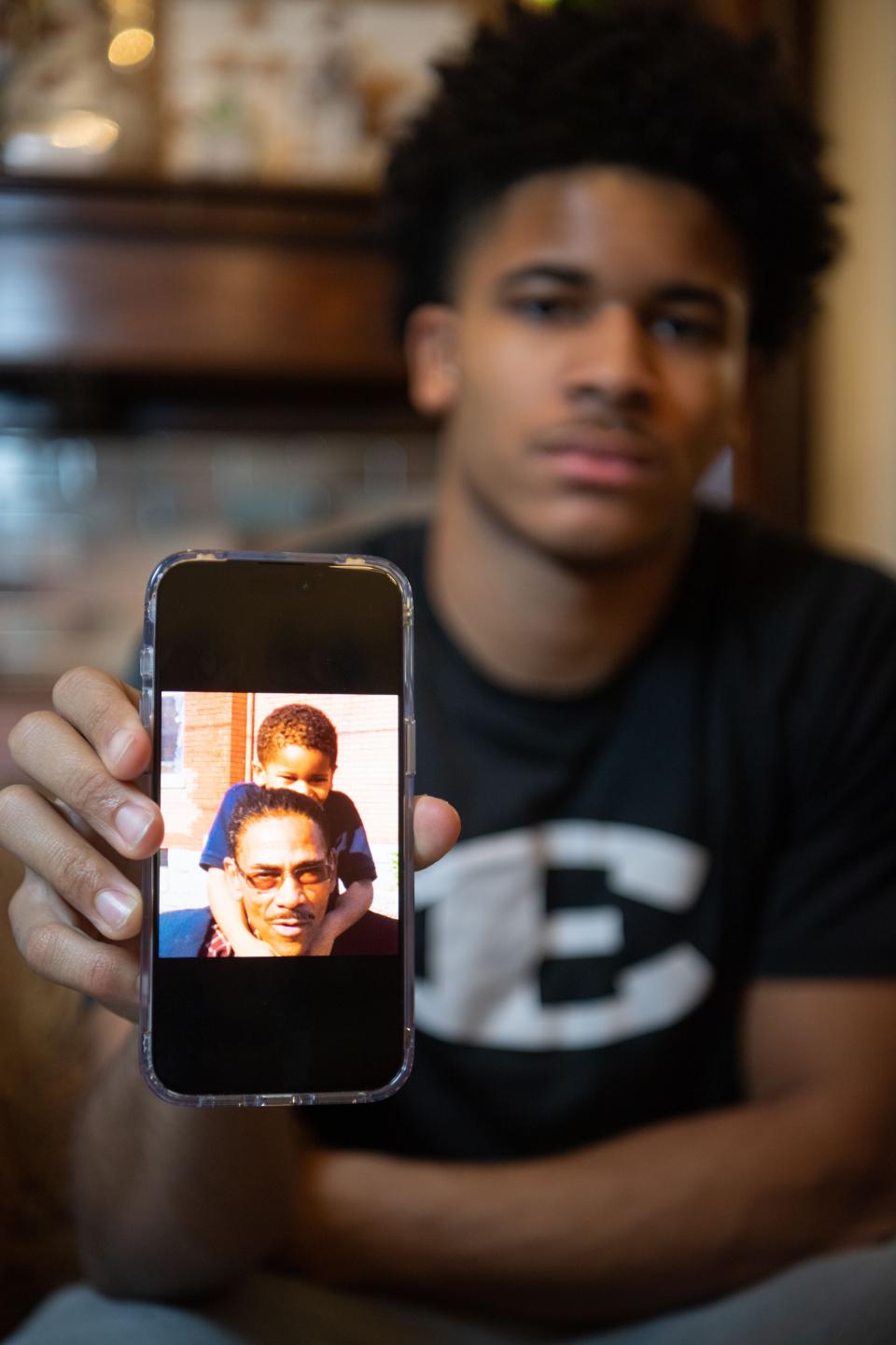 Akeem Batey, 15, holds up a picture with his grandfather, King Madison Hollands when he was younger in Nashville, Tenn., Friday, Jan. 5, 2024.