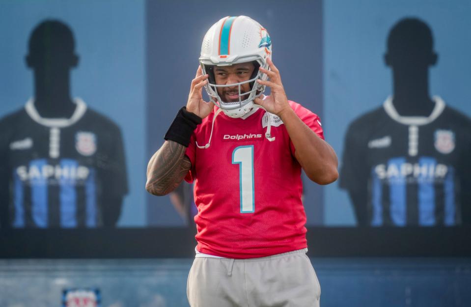 Miami Dolphins quarterback Tua Tagovailoa holds his helmet during a practice session in Frankfurt, Germany, Wednesday, Nov. 1, 2023. The Miami Dolphins are set to play the Kansas City Chiefs in a NFL game in Frankfurt on Sunday Nov. 5, 2023. (AP Photo/Michael Probst)