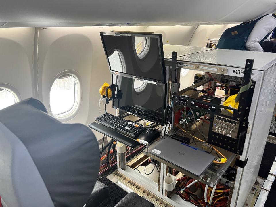 One of the workstations with two computer monitors and a plush grey seat.