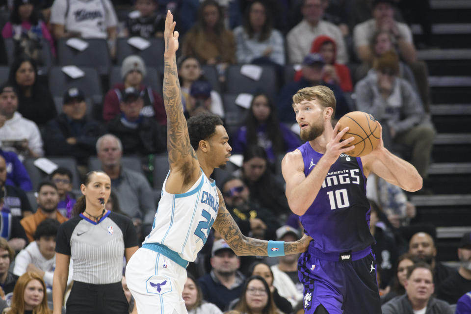 Charlotte Hornets forward P.J. Washington, left, guards Sacramento Kings forward Domantas Sabonis (10) during the first quarter of an NBA basketball game in Sacramento, Calif., Tuesday, Jan. 2, 2024. (AP Photo/Randall Benton)