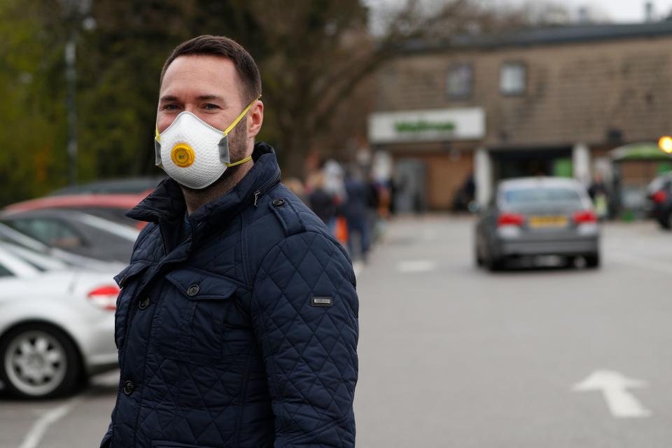 A man wears a protective face mask outside a Waitrose supermarket in Frimley, south west of London on March 29, 2020, as life in Britain continues during the nationwide lockdown to combat the novel coronavirus pandemic. - Prime Minister Boris Johnson warned Saturday the coronavirus outbreak will get worse before it gets better, as the number of deaths in Britain rose 260 in one day to over 1,000. The Conservative leader, who himself tested positive for COVID-19 this week, issued the warning in a leaflet being sent to all UK households explaining how their actions can help limit the spread. "We know things will get worse before they get better," Johnson wrote. (Photo by Adrian DENNIS / AFP) (Photo by ADRIAN DENNIS/AFP via Getty Images)