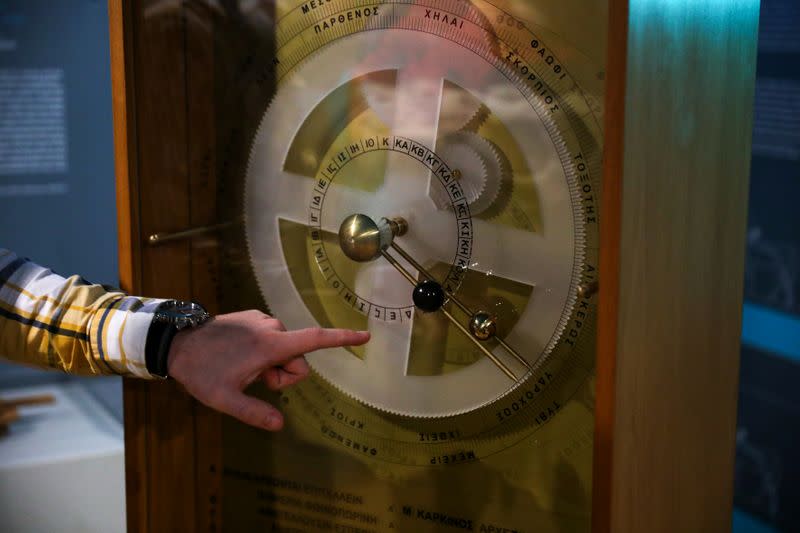 A Kotsanas Museum of Ancient Greek Technology employee presents a replica of the ancient Antikythera Mechanism, in Athens