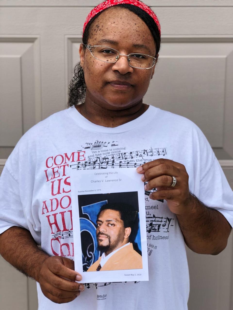 Sanya Lawrence holds a photo of her husband, Charles Lawrence, who died from the coronavirus in May 2020. (Photo: Courtesy of Sanya Lawrence)