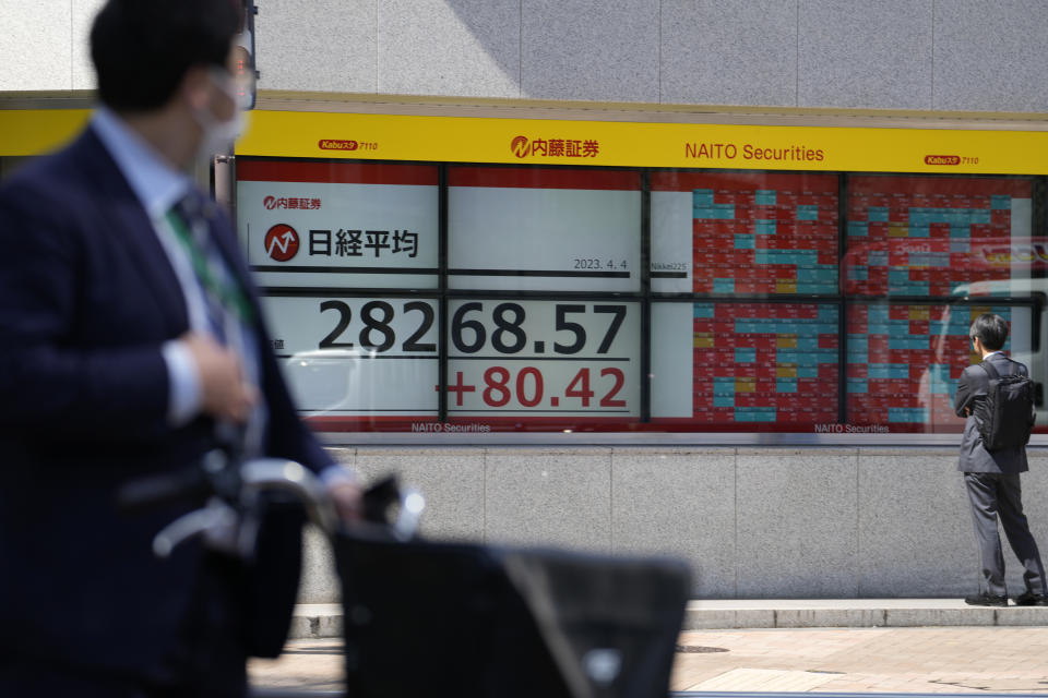 People look at an electronic stock board showing Japan's Nikkei 225 index at a securities firm Tuesday, April 4, 2023 in Tokyo. (AP Photo/Shuji Kajiyama)
