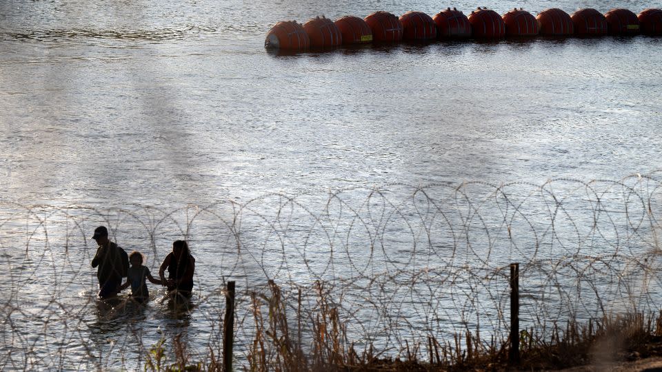 Migrants cross the Rio Grande river near the buoy barriers on September 11, 2023 in Eagle Pass, Texas. - Brandon Bell/Getty Images