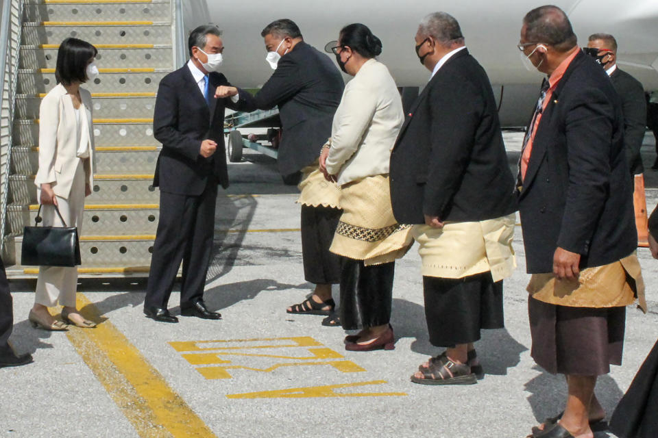 China's Foreign Minister Wang Yi, second left, is welcomed on the tarmac by officials on his arrival in Nuku'alofa, Tonga, Tuesday, May 31, 2022. Wang and a 20-strong delegation are in Tonga as part of an eight-nation Pacific Islands tour that comes amid growing concerns about Beijing's military and financial ambitions in the South Pacific region. (Marian Kupu/ABC via AP)