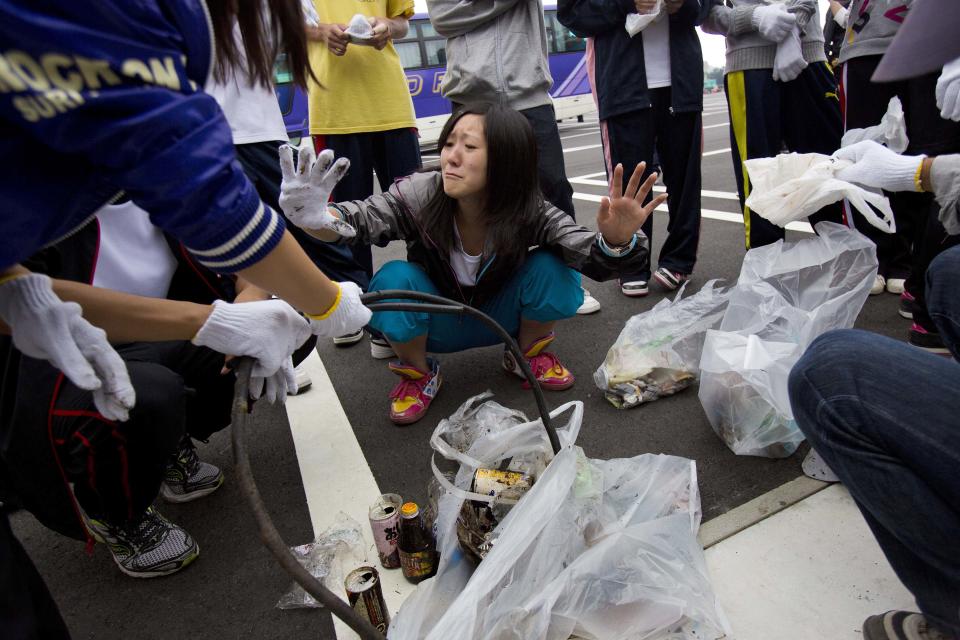 In this Thursday, Aug. 29, 2013 photo, Japanese students sort through garbage they collected on and around Mount Fuji in Japan during a school outing to learn about the mountain environment. The Japanese cheered the recent recognition of Mount Fuji as a UNESCO World heritage site, though many worry that the status may worsen the damage to the environment from the tens of thousands who visit the peak each year. (AP Photo/David Guttenfelder)