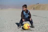 <p>Afghan boy five-year-old Murtaza Ahmadi, a young Lionel Messi fan, plays football in Kabul on February 1, 2016. Barcelona star Lionel Messi is hoping to arrange a meeting with an Afghan boy who shot to fame after pictures of him dressed in a striped plastic bag jersey went viral, Kabul’s football federation said on February 1. (Photo: Shah Marai/ AFP/Getty Images) </p>