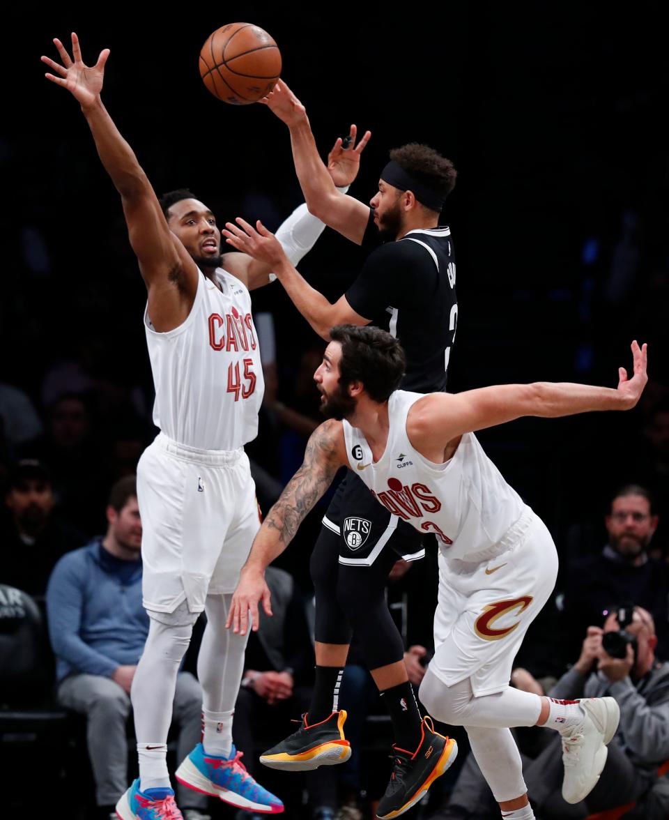 Cavaliers guards Donovan Mitchell (45) and Ricky Rubio (13) defend Nets guard Seth Curry, Tuesday, March 21, 2023, in New York.