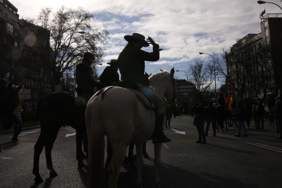 Protesters on horseback take part in a march down the Castellana Boulevard in defence of Spanish rural areas during a protest in Madrid, Spain, Sunday, Jan. 23, 2022. Members of rural community are demanding solutions by the government for problems and crisis in the Rural sector. (AP Photo/Paul White)