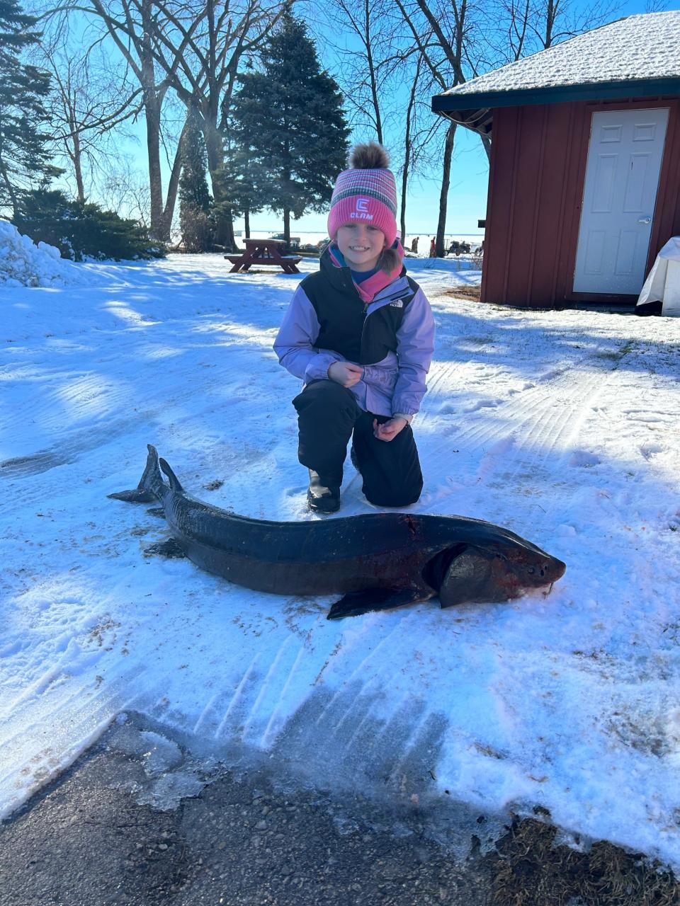 Elizabeth Meyer, 12, of Fond du Lac, posing with the first sturgeon she had ever caught outside Jim and Linda's Supper Club in Pipe.